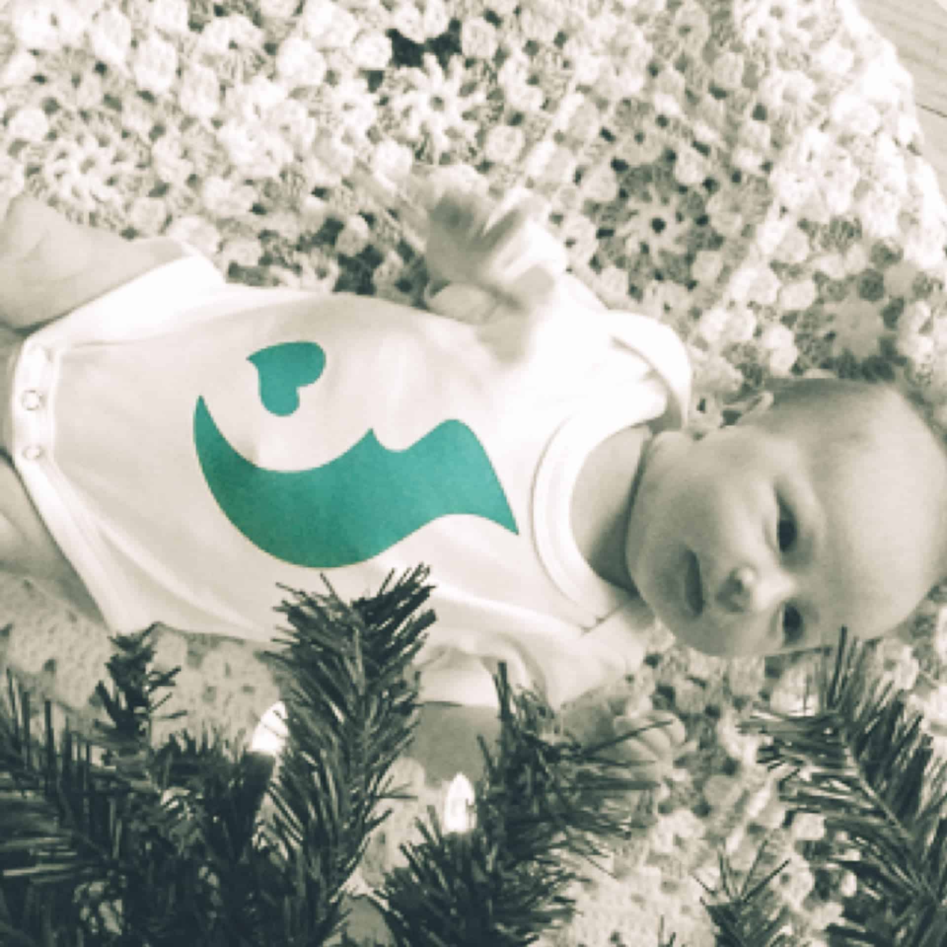 Baby under a Christmas tree.